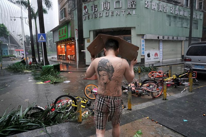 Un hombre se protege de la lluvia en Shenzhen, en la provincia china de Cantón. El huracán Mangkhut ha tocado tierra en esta parte del país tras dejar decenas de muertos en Filipinas. REUTERS/Jason Le