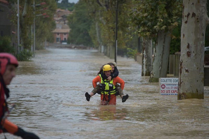 Un bombero rescata a una vecina en Trebes, cerca de Carcasona. Pascal PAVANI / AFP