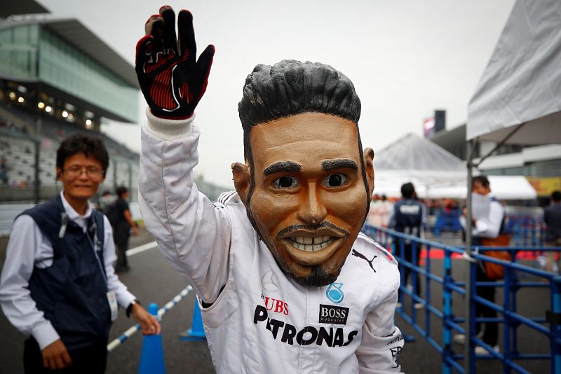 Un fan japonés disfrazado del piloto británico de Fórmula Uno Lewis Hamilton (Mercedes AMG) saluda a los espectadores.