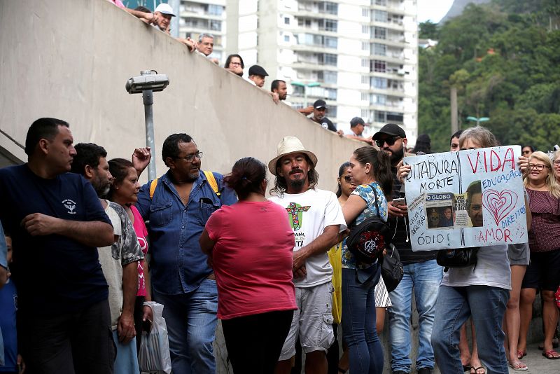 Los votantes esperan turno en el colegio electoral de la Favela de Rocinha, en la ciudad de Río de Janeiro