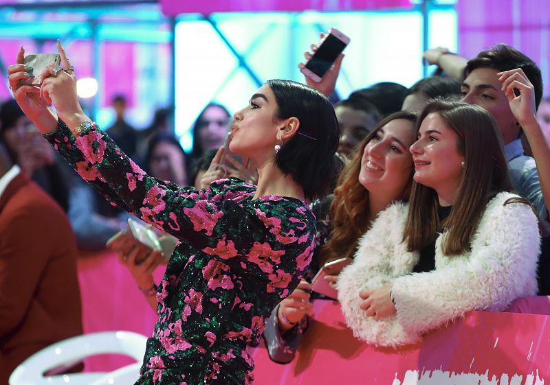 La cantante Dua Lipa se toma una foto con sus fans sobre la alfombra roja
