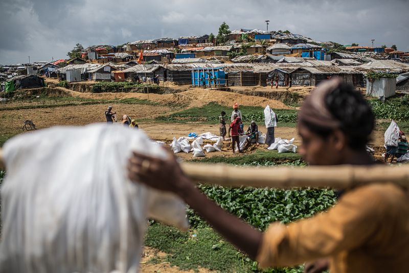 Un grupo de refugiados llena y transporta bolsas de tierra para fortalecer los cimientos de sus frágiles refugios, en preparación frente a las lluvias, los vientos y las inundaciones de la época del monzón y de ciclones.