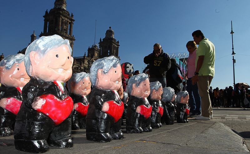 Seguidores de Obrador observan muñecos que representan al mandatario en la plaza del Zócalo, en Ciudad de México