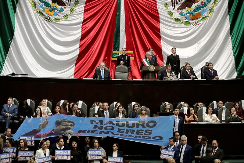 Un grupo de congresistas despliega una pancarta en la que se lee "Maduro, no eres bienvenido"