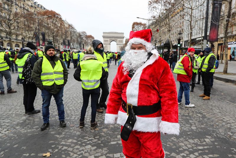 Papá Noel posa junto a varios manifestantes en los Campos Elíseos