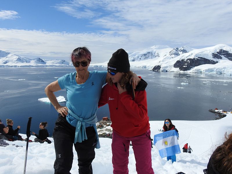 La fundadora de Homeward Bound, Fabian Dattner (a la izquierda de la imagen), sube al mirador con una integrante de la expedición, en Bahía Paraíso, considerado uno de los lugares más bellos de la Antártida