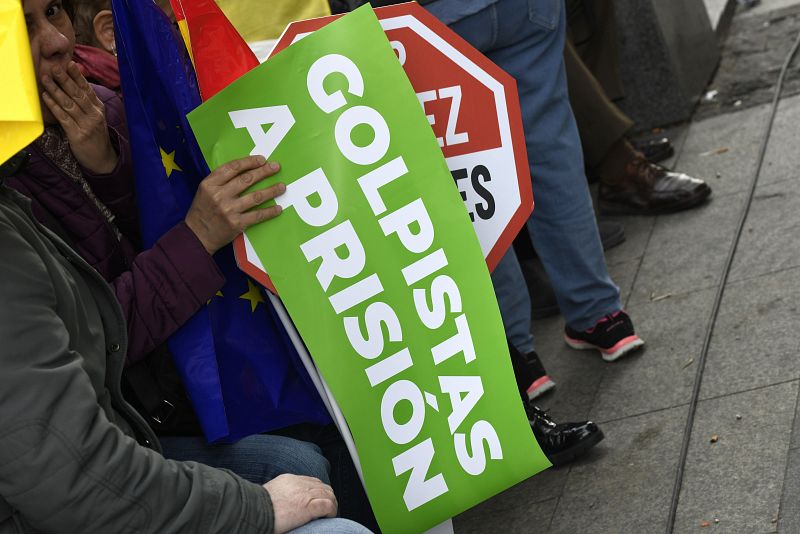 Un asistente a la manifestación con una pancarta en la que se lee "Golpistas a prisión"