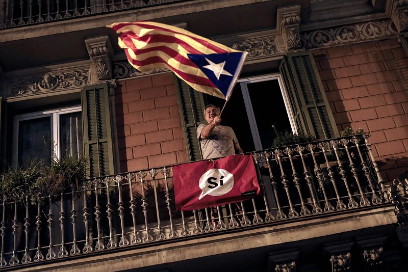 Un independentista ondea una bandera desde un balcón en Barcelona