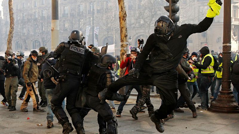 Un manifestante con el chaleco en la mano agrede a un policía en París