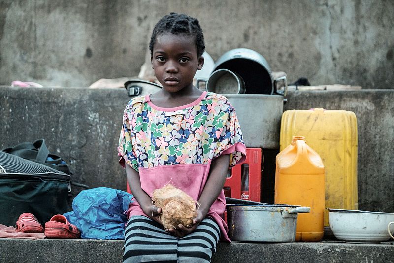 Una niña con un coco en sus manos en un refugio en el distrito de Búzi, provincia de Sofala, Mozambique
