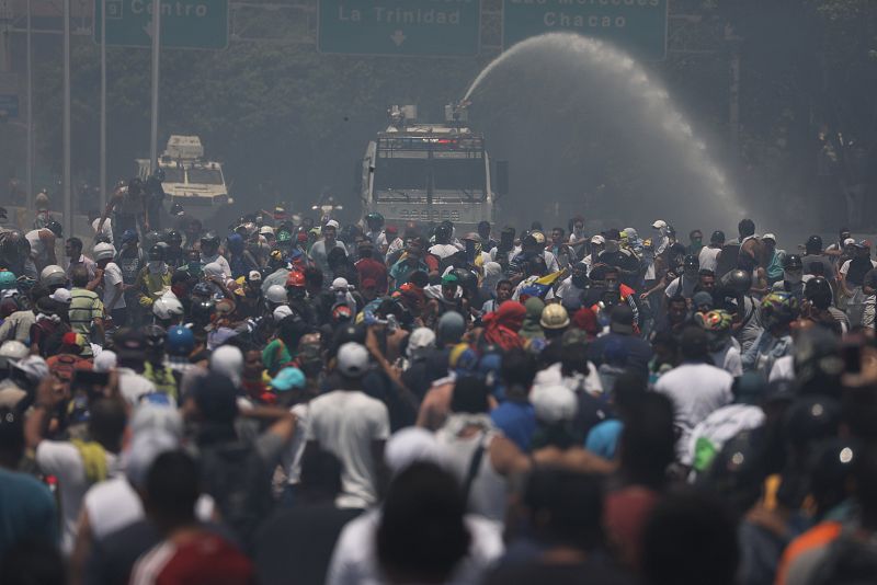 Simpatizantes del presidente de la Asamblea Nacional, Juan Guaidó, se enfrentan a las fuerzas oficialistas de las Fuerzas Armadas Bolivarianas, durante una manifestación en apoyo a su levantamiento contra el gobierno de Nicolás Maduro.