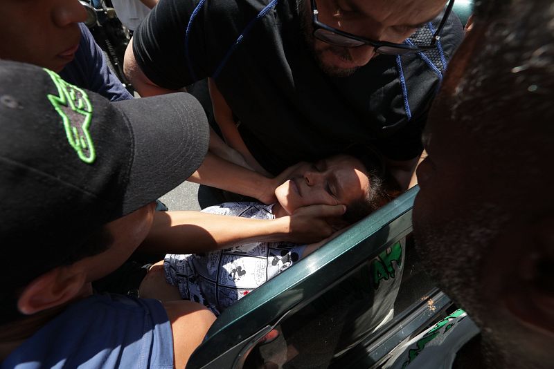 Simpatizantes del presidente de la Asamblea Nacional, Juan Guaidó, ayudan a una mujer herida por una bala en el estómago. 