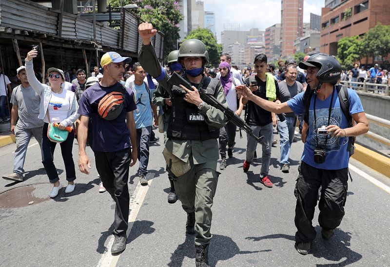 Un miembro de la Guardia Nacional de Venezuela hace gestos mostrando su apoyo al líder de la oposición.