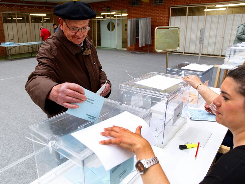 Un hombre deposita su voto en las elecciones municipales, autonómicas y europeas en un colegio electoral en Vitoria