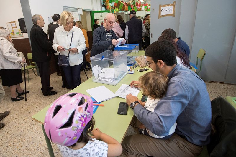 Un vocal de una mesa cuida de sus hijos durante la jornada electoral