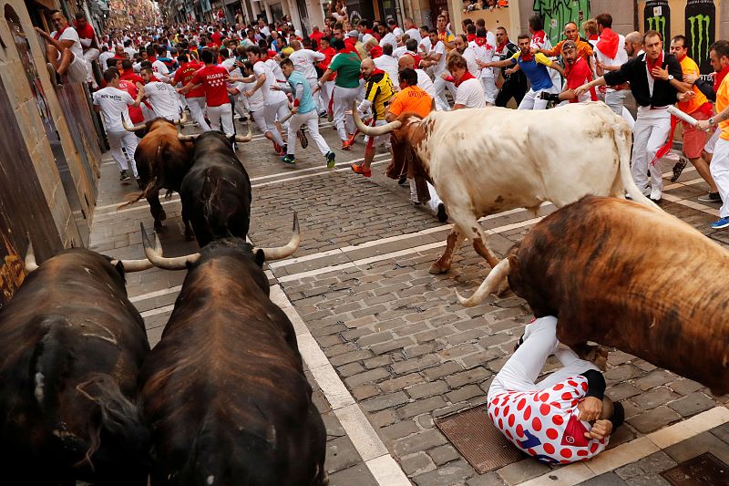 Uno de los mozos se protege en el suelo al paso de los toros de La Palmosillana