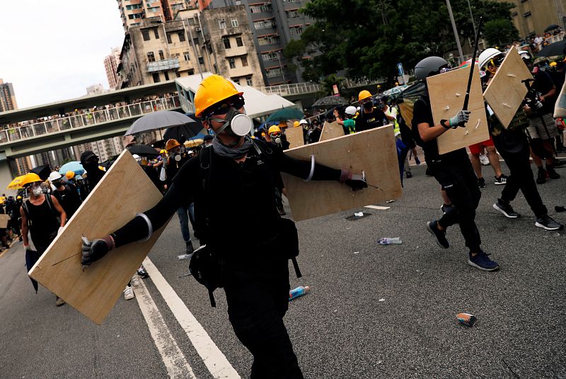 Los manifestantes avanzan protegidos con escudos