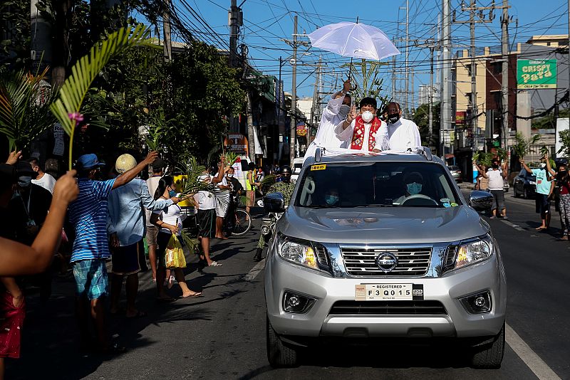 Un sacerdote católico reparte bendiciones desde un vehículo en las calles de Manila, Filipina