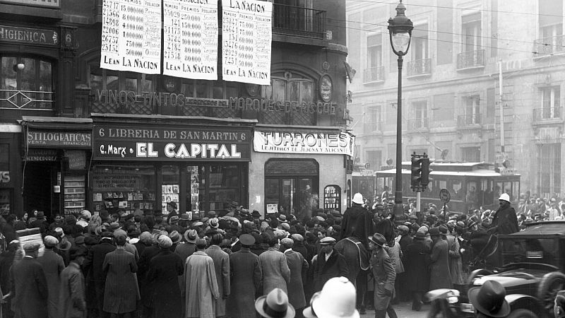 Multitud de personas se acercan a la Puerta del Sol para comprobar los números premiados en el Sorteo de Navidad.