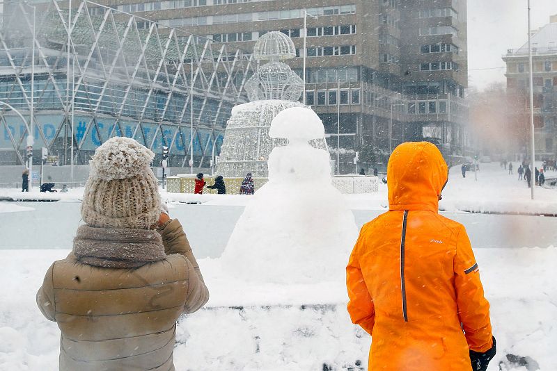 Una estatua de una menina reproducida con nieve en la Plaza de Colón en Madrid cubierta de nieve.