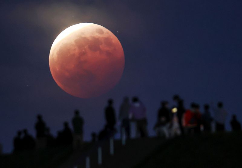 Un grupo de personas observa la superluna en el parque Moerenuma en Sapporo, en el norte de Japón.