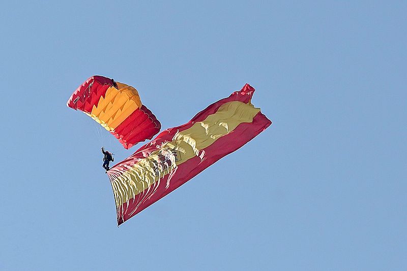 La bandera de España llega por el aire al desfile de la Fiesta Nacional