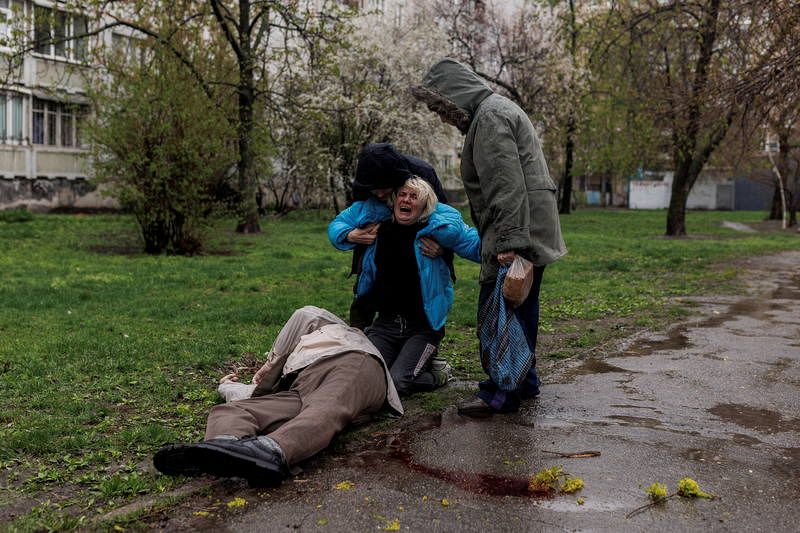 Una mujer llora sobre el cuerpo de su padre, mientras su esposa lo acompaña, tras los bombardeos rusos, mientras continúa el ataque de Rusia a Ucrania, en Járkov