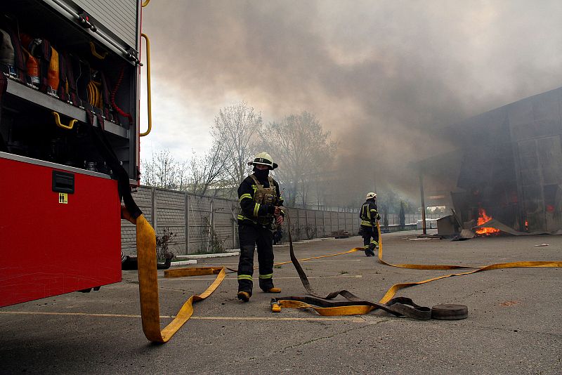 Bomberos trabajan en las tareas de extinción de un incendio desatado en un almacén de acero tras una ataque ruso en la ciudad de Járkov