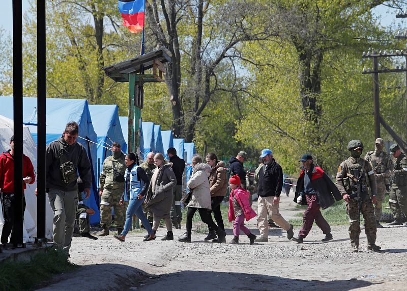 Los civiles, evacuados de los alrededores de Azovstal, caminan hacia un centro de alojamiento temporal en el pueblo de Bezimenne en la región de Donetsk.