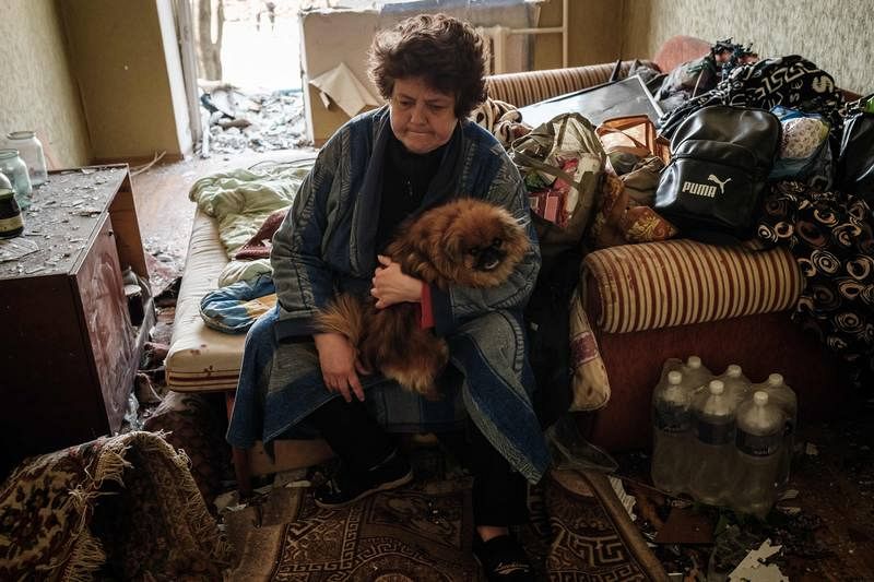 Una anciana se sienta en su cama con su perro en un apartamento dañado por la explosión de un misil en Kramatorsk, al este de Ucrania.