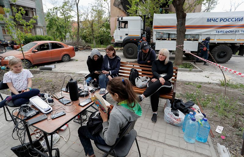 Un grupo de personas carga sus móviles en Mariúpol