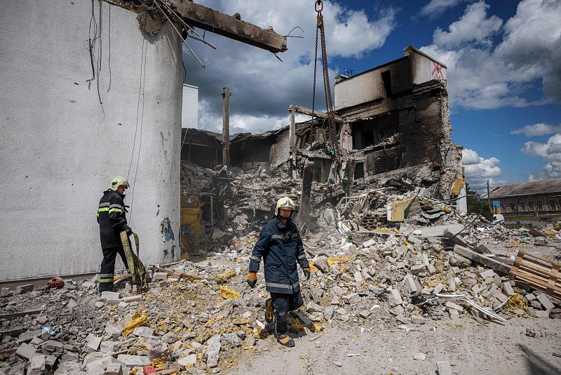 Los bomberos retiran los escombros de un centro cultural destruido, utilizado como centro de ayuda humanitaria, alcanzado por un ataque aéreo el 12 de mayo, en Derhachi, cerca de Járkov