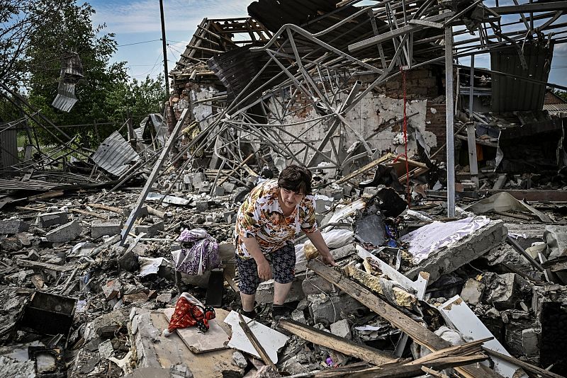 Los residentes buscan sus pertenencias entre los escombros de su casa después de que un ataque destruyera tres casas en la ciudad de Sloviansk.