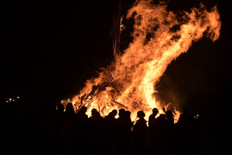 Cientos de gijoneses celebran, junto a las hogueras, la Noche de San Juan en la playa de Poniente.