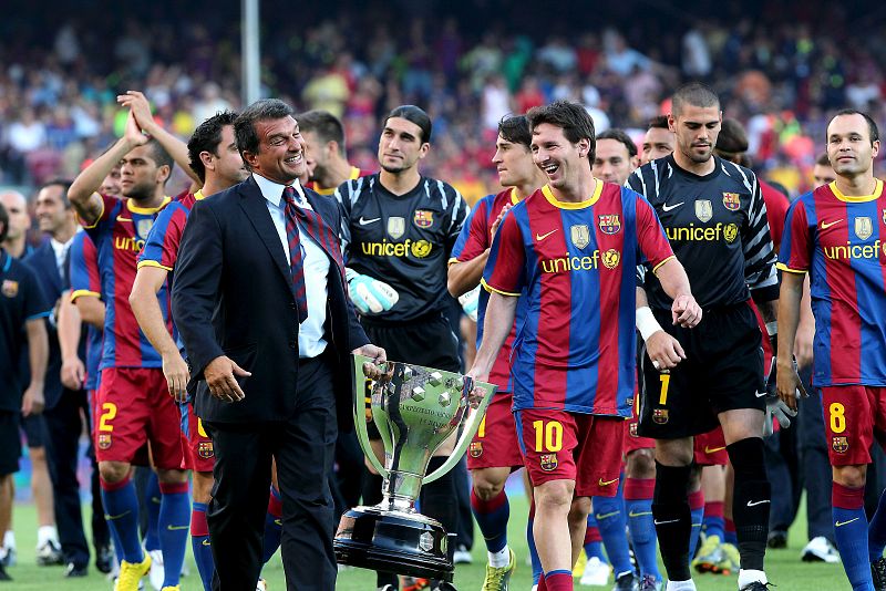  25/08/2010.- El argentino Leo Messi (d) y el ex presidente Joan Laporta, junto al resto del equipo, sostienen la copa que les acredita como campeones de la liga 2009-2010 en los prolegómenos del partido que les enfrenta a AC Milán, correspondiente a
