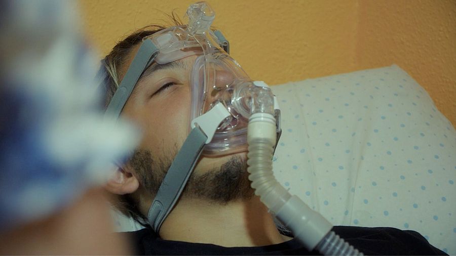 Cara de joven en la cama con un respirador