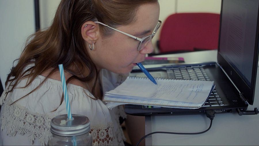 chica sin manos escribe con la boca