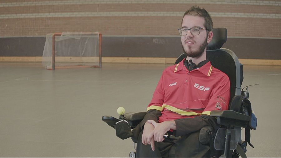 joven sentado en una silla de ruedas en una pista de hockey