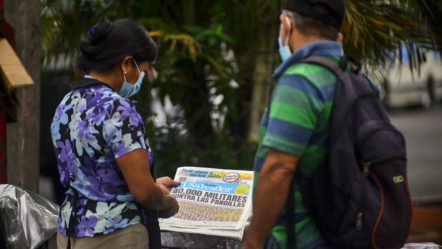 La gente lee un periódico que anuncia el objetivo del gobierno de desplegar 40.000 militares contra las pandillas (Camilo Freedman/Getty Images)