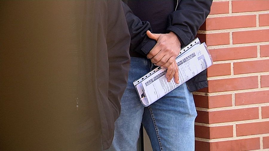 Ciudadano espera en la cola de una oficina de extranjería con papeles en la mano para ser atendido.