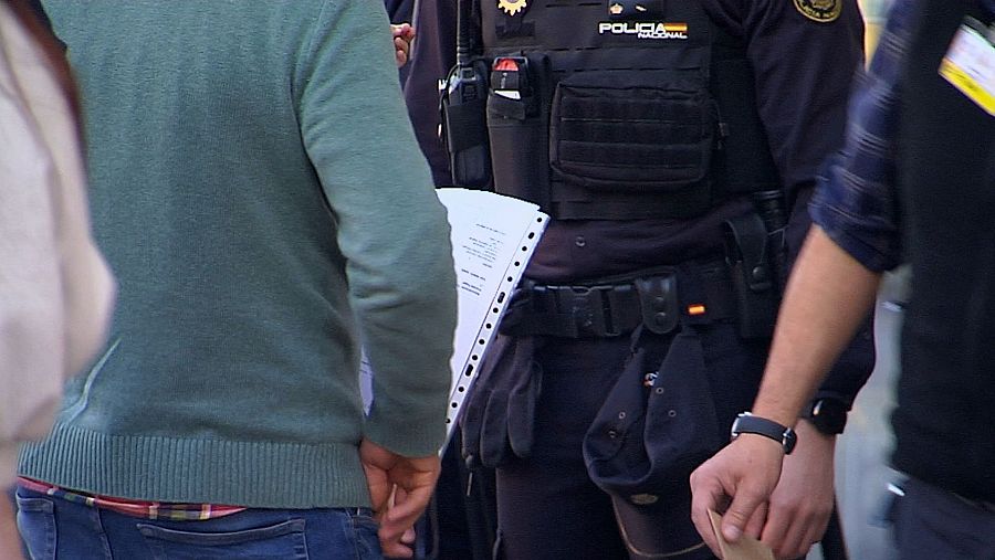 Cola de oficina de extranjería con ciudadanos y policías.