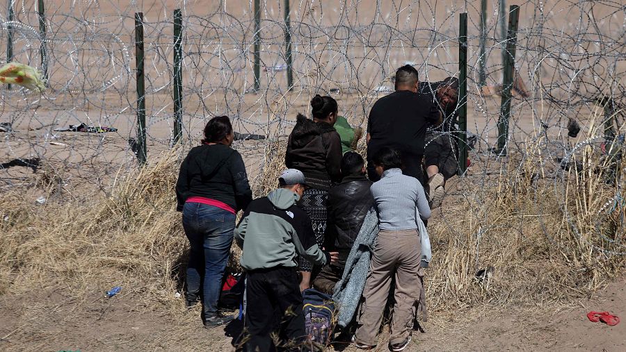 Un grupo de personas trata de cortar el alambre de espino instalado en el Río Grande