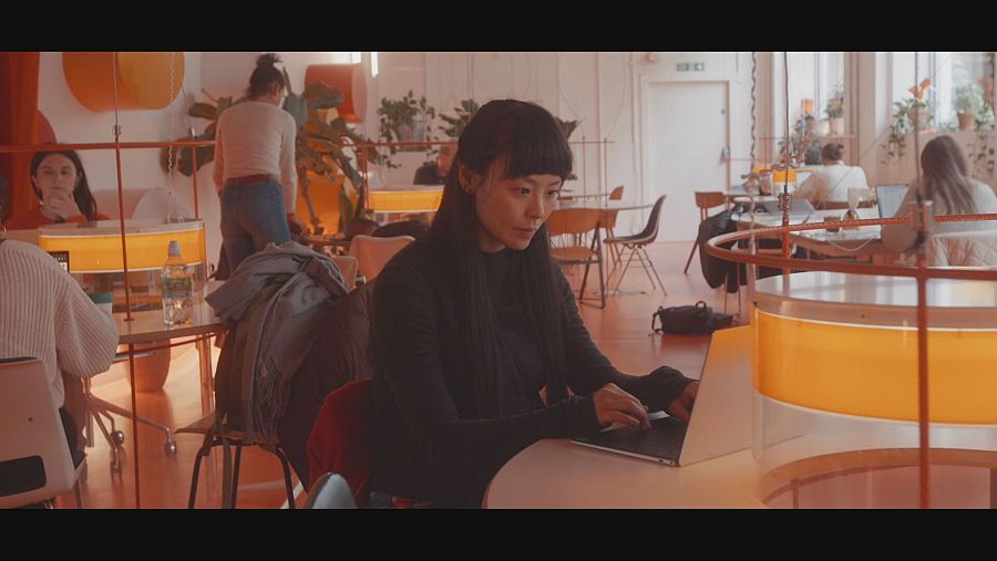 Mujer joven trabaja con un ordenador en una oficina.