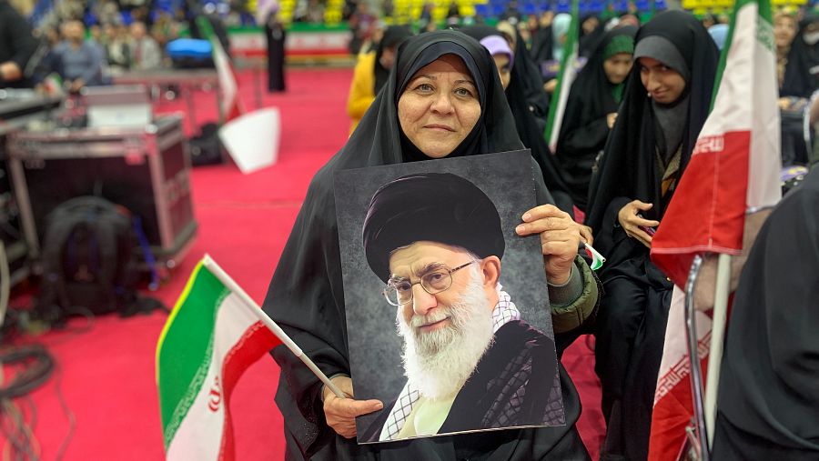 Una mujer sujeta la bandera y la foto del Líder Supremo en un mitin a favor de la República Islámica