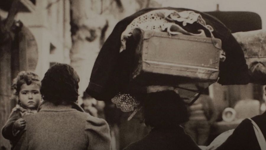 Dos mujeres, una con un bebé en brazos y otra con una maleta, parte del archivo fotográfico del Museo de Historia de la Inmigración.