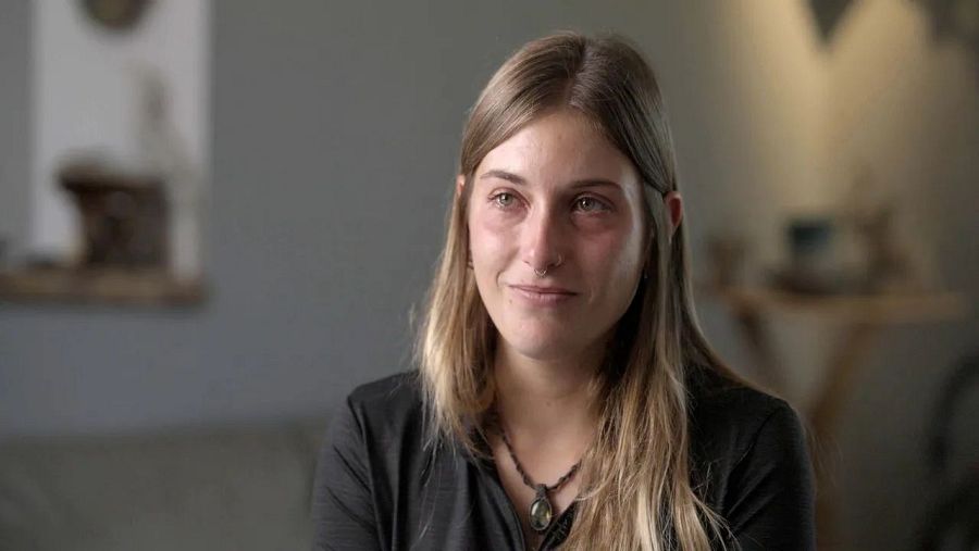 Chica sentada con ojos llorosos sobre fonfo desenfocado