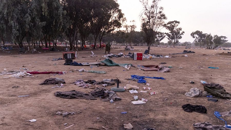 Suelo con ropa y botellas tiradas , dos soldados y todo arrasado