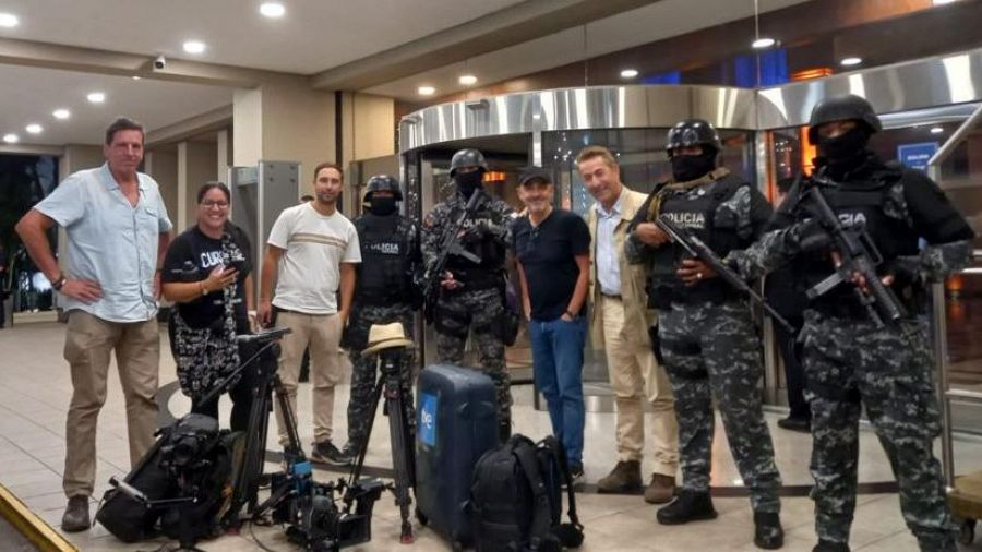 Periodistas y policías posan de pie para la foto.