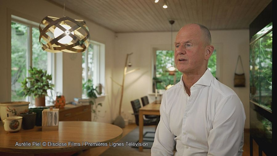 Hombre con camisa blanca sentado en un salón