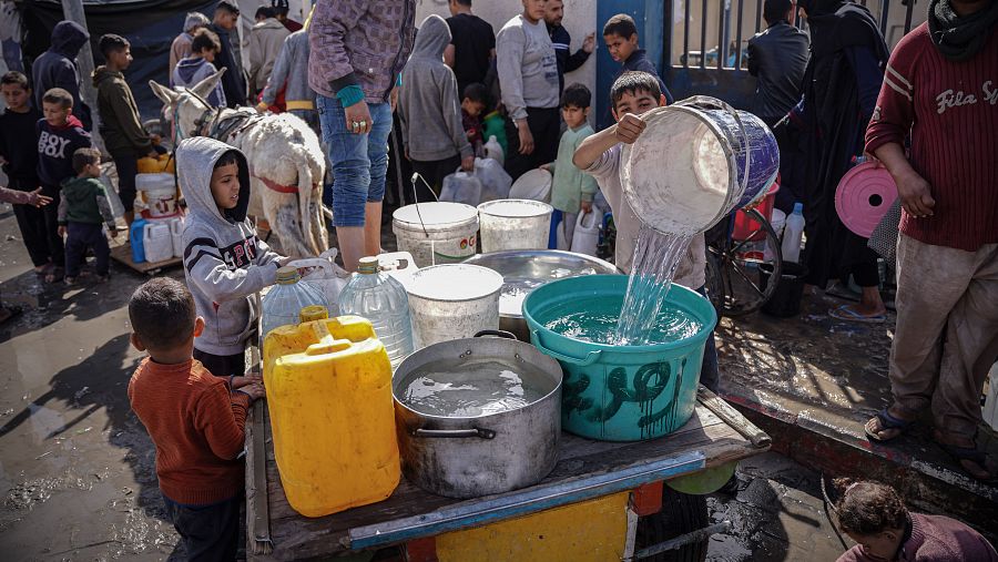 Niños palestinos recogen agua en Ráfah, Gaza.